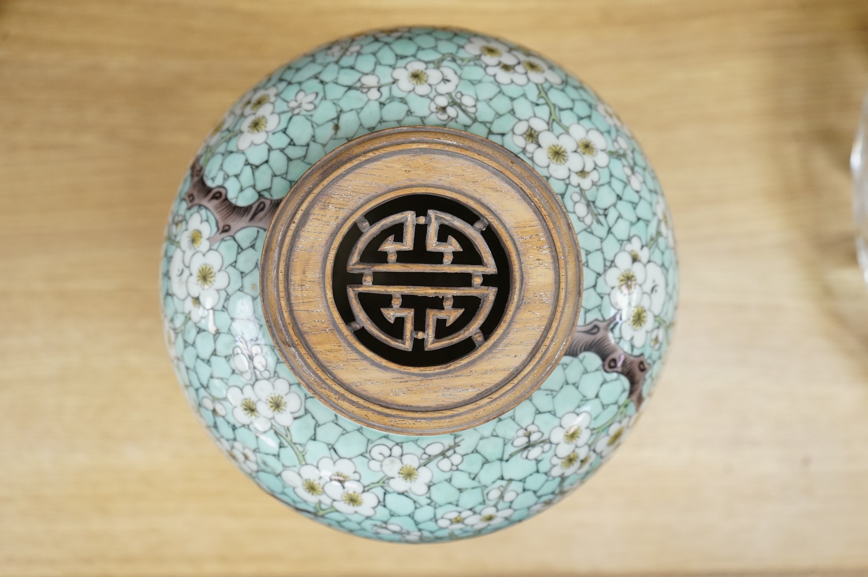 A Chinese famille verte enamelled prunus jar, 19th century, with wood cover and stand, 25cm high